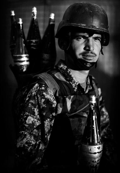 El soldado afgano Aijad, tayico, porta granadas en el puesto de combate del valle de Arghandab.