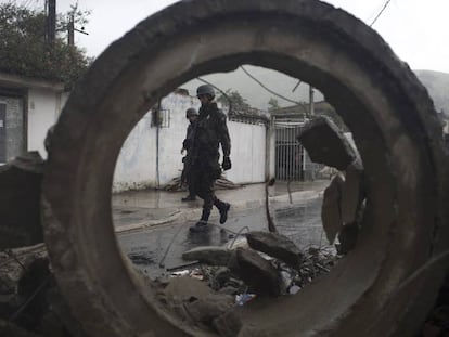 Soldados passam por barricada durante opera&ccedil;&atilde;o surpresa na favela da Coreia, no Rio de Janeiro.