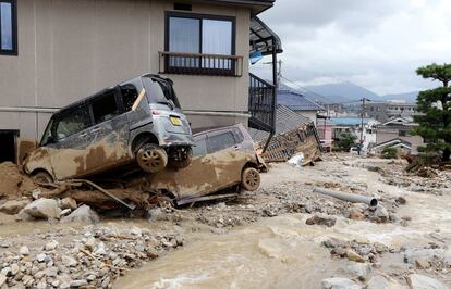 Dos coches destrozados, tras las lluvias torrenciales que han provocado un fuerte corrimiento de tierra.