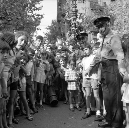 Un munt de nens i dos policies a la festa major de la Barceloneta, el 1970, en una imatge de Pere Català i Roca.