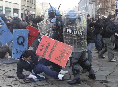 Un manifestante es golpeado por policías durante la manifestación en Milán.