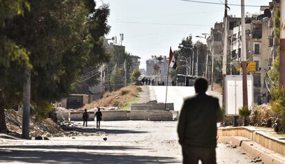 Um soldado regular sírio observa o posto de controle insurgente que dá acesso à sitiada localidade da Moadamiya.