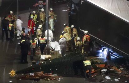 Personal de emergencias trabaja junto al camión que irrumpió en un mercadillo navideño en Berlín.