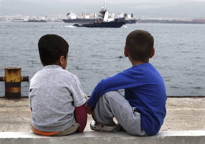 Dois meninos refugiados observam o mar, na Gr&eacute;cia.