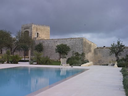 Bajo la torre está la puerta de acceso a esta finca de dos hectáreas en el sureste de Sicilia. La piscina queda fuera de los muros. La butaca junto al agua es el modelo Lucy, de Vincent Sheppard.
