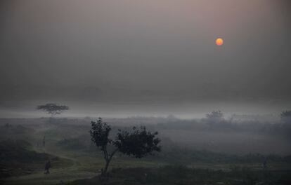 Varios campesinos se dirigen a trabajar sus tierras al amanecer en las afueras de Nueva Delhi (India). 