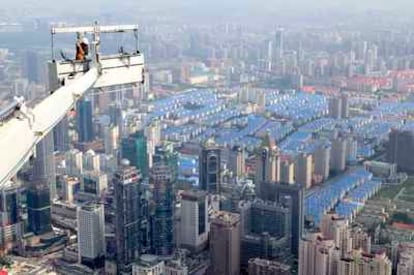 Vista de Shangai desde el aire, mientras unos obreros realizan reformas en el Centro Financiero Mundial.