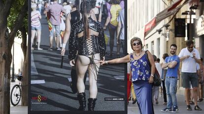 Una mujer señala una de las fotografías de 'Orgullo de Sevilla'.