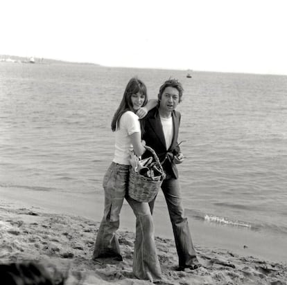 Cannes 1974. La playa del pueblo que alberga el festival se erigió un estudio fotográfico improvisado por el que han pasado todas las celebrities. En la imagen, Birkin pasea con Serge Gainsbourg por la orilla con un estilismo similar al anterior, aunque algo más folk gracias a los pamtalones de campana de patchwork y pata de elefante. Como complemento, una cesta de miembre de la que Birkin se hizo inseparable durante décadas.