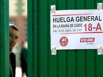 Un trabajador mira tras la puerta de una empresa de autobuses, durante la huelga en solidaridad con la plantilla de Delphi, ayer en Cádiz.