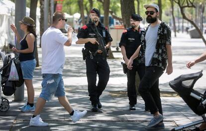 Patrulla de los mossos con armas largas por el Paseo Juan de Borbón de la Barceloneta.