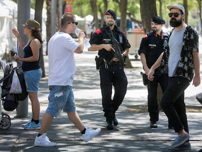 Patrulla de los mossos con armas largas por el Paseo Juan de Borbón de la Barceloneta.