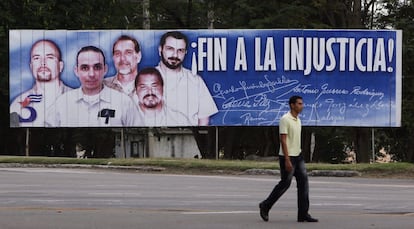 Un hombre camina frente a una valla con la imagen del llamado grupo de "Los Cinco", en La Habana (Cuba), 17 de diciembre de 2014. El Gobierno de EE.UU. liberó a los tres espías cubanos Gerardo Hernández, Ramón Labañino y Antonio Guerrero de "Los Cinco" a cambio de un oficial de inteligencia estadounidense que llevaba casi 20 años preso en Cuba, informaron altos funcionarios. Asimismo, precisaron que la liberación del contratista estadounidense Alan Gross, preso en La Habana desde 2009 y también anunciada, no fue a cambio de la de esos tres espías, sino "por razones humanitarias" tras un acuerdo con el Gobierno cubano.