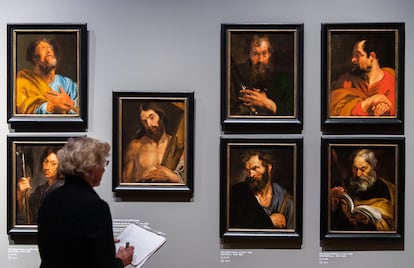 A journalist is standing in front of the depictions of saints by Anthonis van Dyck at the exhibition "Anthonis van Dyck (1599-1641)" in the Alte Pinakothek