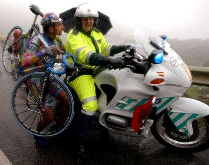 El italiano Davide Bramati pide ayuda a un motorista de la Guardia Civil tras romper su bicicleta en la ascensión al Angliru en 2002.