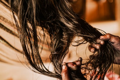 Marneli Birry, de 10 años, trenza el pelo de su madre Liria Cheito en la comunidad de Puerto Antioquia, Chocó.
