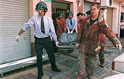 Momento en el que era sacado del edificio, ayer en Manises, el cuerpo de una de las víctimas del incendio.