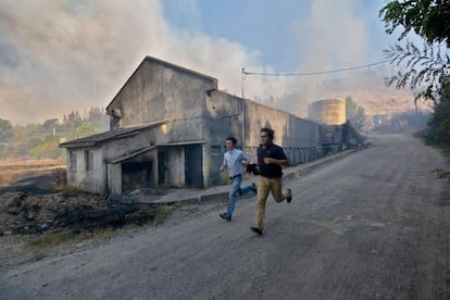 Dos hombres corren durante un incendio forestal, en la localidad de Concepción (Chile).