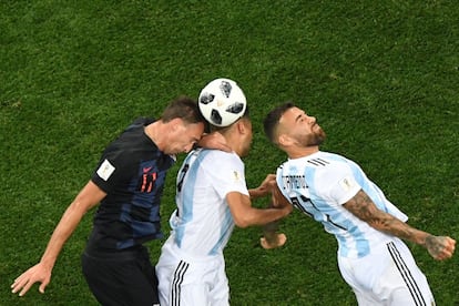 Mario Mandzukic, Gabriel Mercado y Nicolás Otamendi saltan para golpear el balón de cabeza.