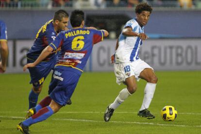 Eliseu busca el pase en la frontal del área ante Ballesteros y Pallardó.