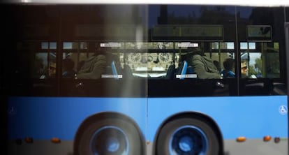 Un autob&uacute;s de la EMT, reflejado en una valla publicitaria en Madrid. 