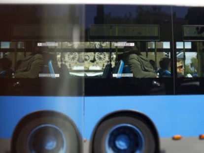 Un autobús de la EMT, reflejado en una valla publicitaria en Madrid.