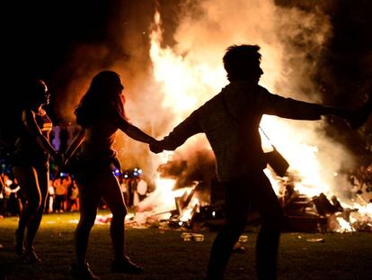 People dance around a bonfire on San Juan's Night in Mundaka, Spain, June 24, 2018. Fires are lit throughout Spain on the eve of Saint John, where people burn objects they no longer want and make wishes as they jump through flames. REUTERS/Vincent West