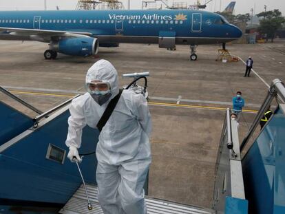 Trabajadores desinfectan un avión en Hanoi, Vietnam. 