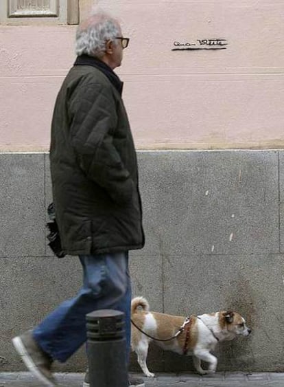 Un hombre pasea  junto a un muro con una reproducción de la firma de la edil.