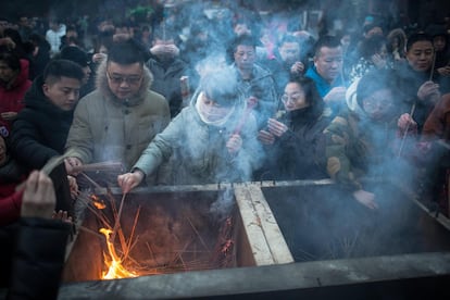 Devotos budistas acendem velas no Templo Yonghegong, em Pequim, na celebração ano Ano do Cachorro, que começa nesta sexta-feira, 16 de fevereiro.