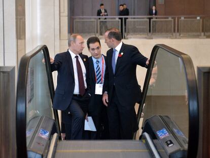 El presidente ruso, Vladímir Putin, conversa con el primer ministro australiano, Tony Abbott, durante la cumbre del foro de Cooperación Económica Asia Pacífico, en Pekín (China).