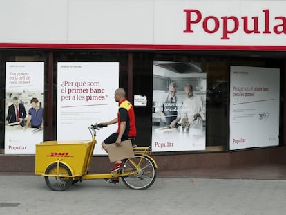 Un repartidor pasa ante una oficina del Banco Popular en Barcelona