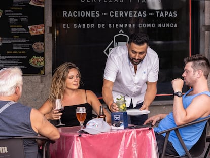 Una camarero atiende a un grupo de clientes en Madrid, el 11 de agosto.