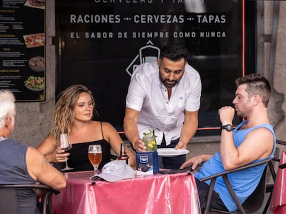 Una camarero atiende a un grupo de clientes en Madrid, el 11 de agosto.