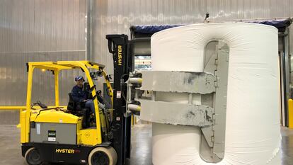 Una elevadora maneja una gran bobina en la fábrica de papel higiénico Charmin.