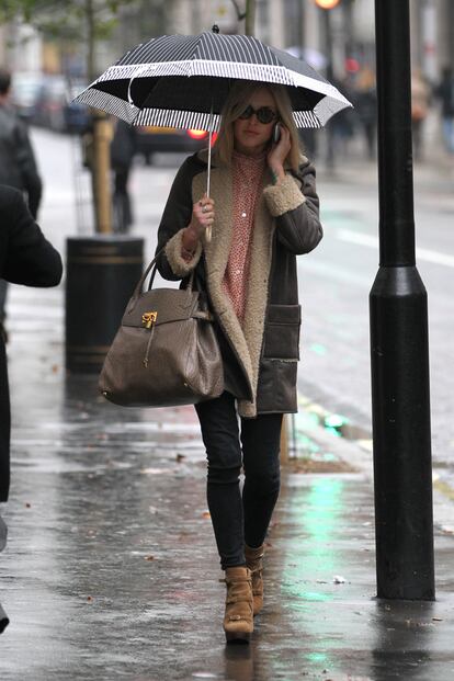 Contra la lluvia, Fearne se cobija bajo un paraguas mientras se refugia en un abrigo de su propia firma.