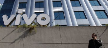Un hombre habla por teléfono frente a un edificio de Vivo.
