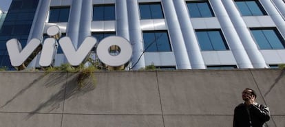 Un hombre habla por tel&eacute;fono frente a un edificio de Vivo.