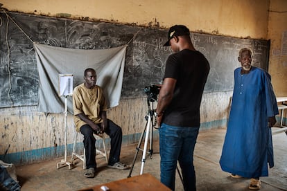 Un trabajador de la Administración toma una fotografía y los datos personales de un desplazado para inscribirlo en un registro en el instituto de Barsalogho, en el centro de Burkina Faso.