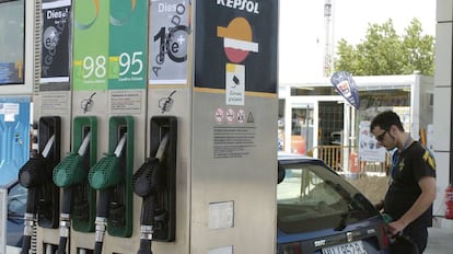 Un joven pone gasolina en una estaci&oacute;n de servicio.