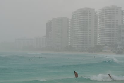 Turistas se bañan en una playa mientras el huracán 'Helene'  se acerca a la península de Yucatán, aún como tormenta tropical, en Cancún, Estado de Quintana Roo, el 24 de septiembre de 2024.