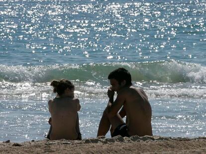 Dos jóvenes, ayer, en la playa de Cortadura, en Cádiz.