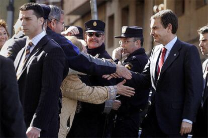 Zapatero saluda, entre fuertes medidas de seguridad, a varios vecinos a su llegada al bario del Carmelo.