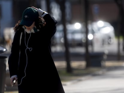 Una mujer abrigada con bufanda y gorro pasea por Madrid el jueves 9 de diciembre.
