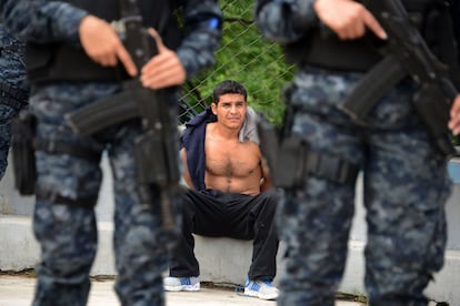 Policías de las fuerzas especiales mantienen bajo custodia a un salvadoreño, supuestamente instructor de las maras, pandillas locales, en Tegucigalpa.