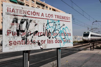 Un cartel advierte junto al paso a nivel de los trenes en Alfafar.