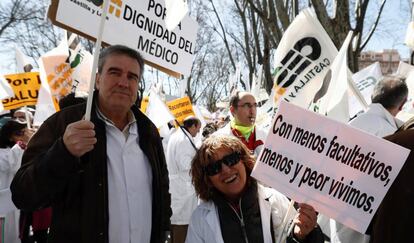Dos médicos portan sendas pancartas durante la manifestación de hoy a las puertas del Ministerio de Sanidad.