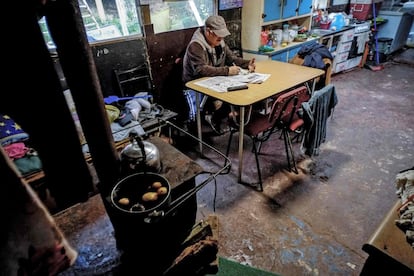 Un hombre de 63 años, se sienta en la cocina de su casa del campamento Pedro del Río Zanartu en Concepción, Chile.