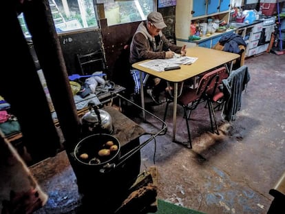 Um homem de 63 anos se senta na cozinha de sua casa no acampamento Pedro del Río Zanartu em Concepción, Chile.