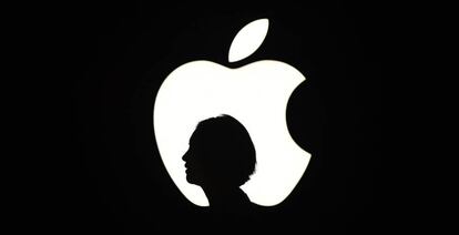 La silueta de una mujer junto a un logo de Apple en un evento en San Francisco.